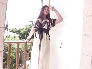 Horny brunette displays her big tits on the terrace